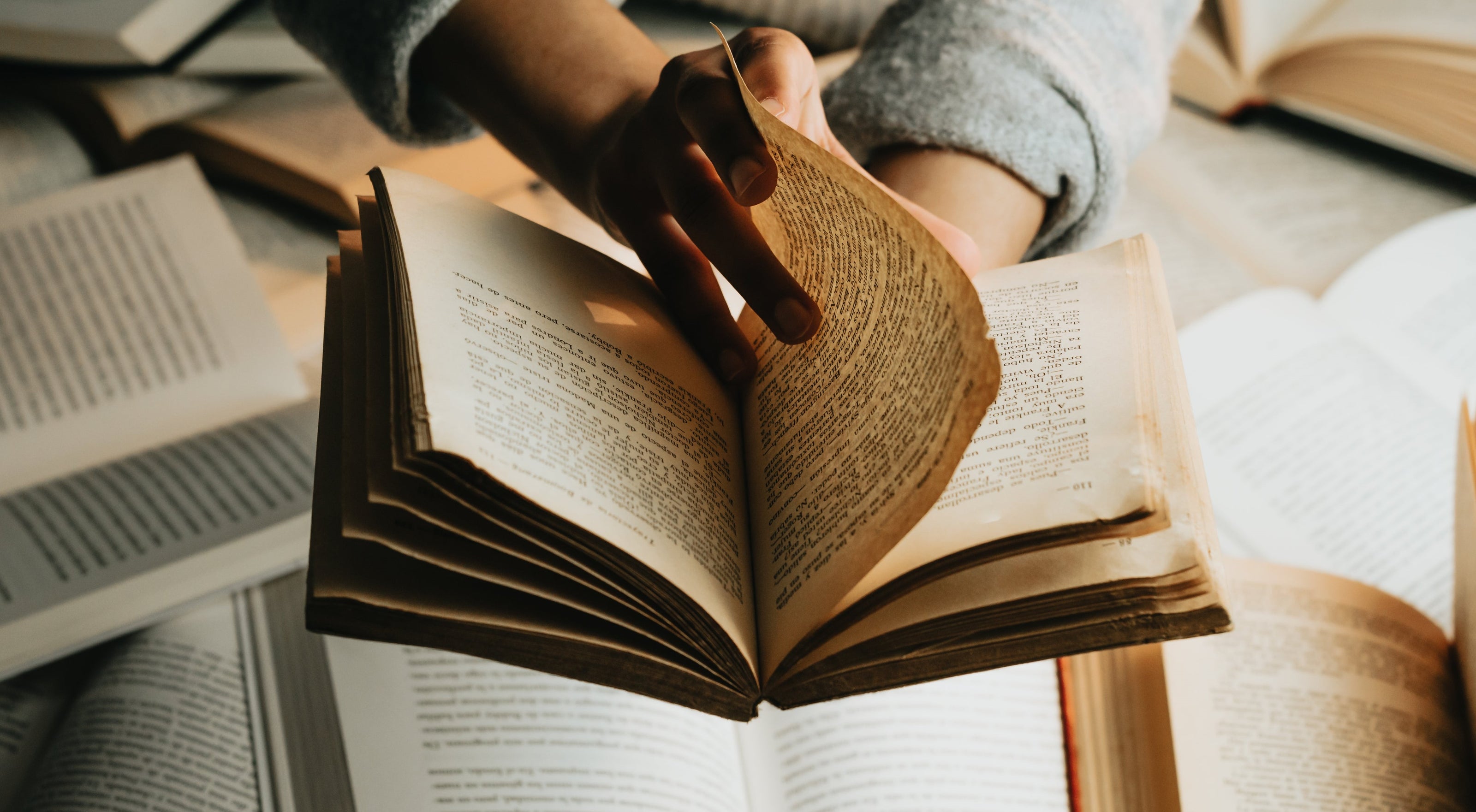 Researcher using open books on desk 